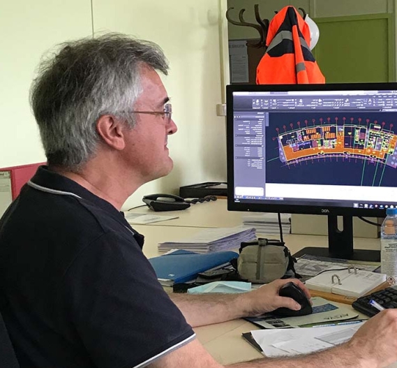 dessinateur entrain de modeliser un batiment en 3D sur logiciel