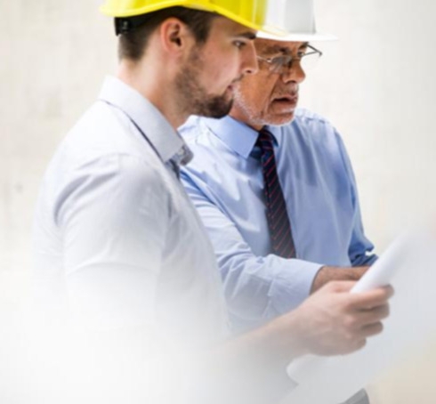 Deux hommes sur un chantier regardant un plan