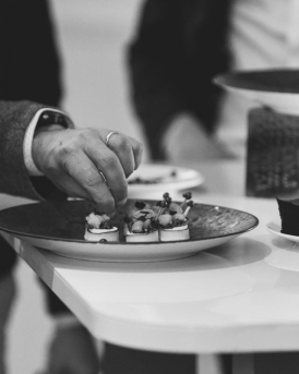Personne prenant un amuse-bouche dans une assiette