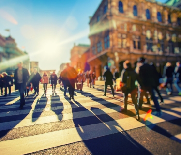 Sunrise with people crossing the street.