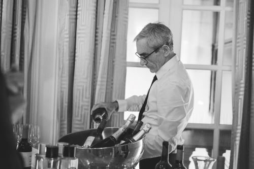 Serveur en train de servir du champagne. Photo noire et blanche